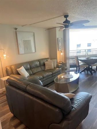 a living room with couches and a dining table with kitchen view