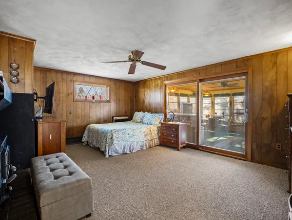 a spacious bedroom with a bed and glass walk in closet