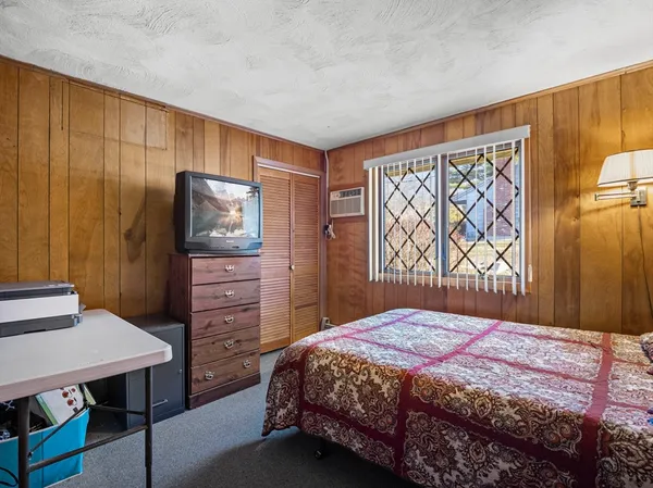 a bedroom with a bed closet and flat tv screen