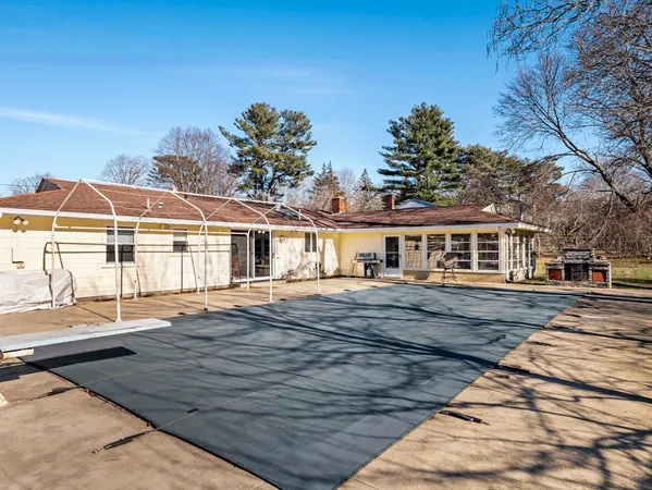 a front view of house with yard outdoor seating and covered with trees