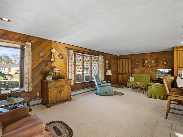 a living room with furniture a flat screen tv and floor to ceiling window