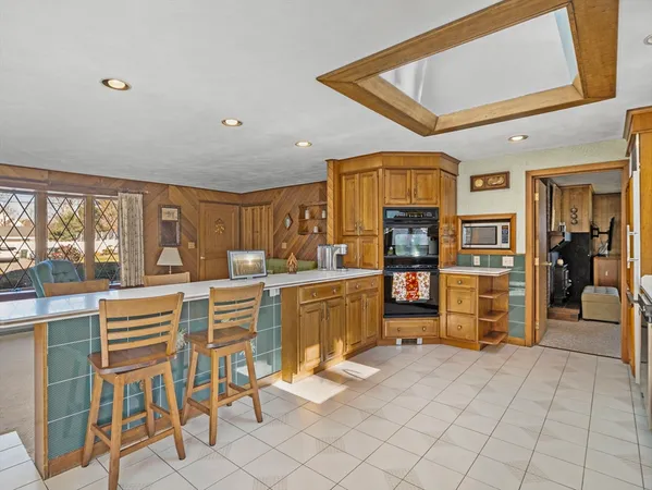 a kitchen with stainless steel appliances kitchen island granite countertop a refrigerator and cabinets