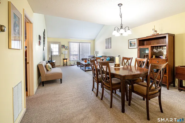a view of a dining room with furniture and a chandelier
