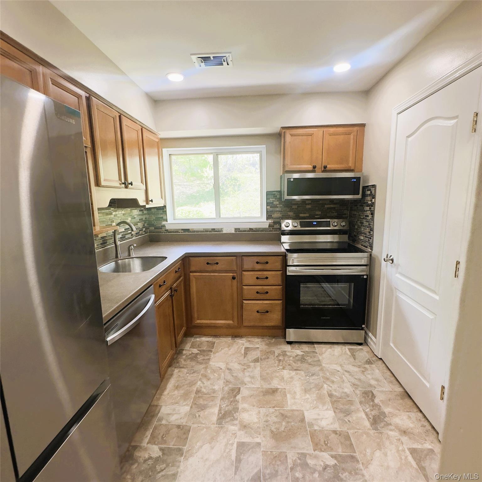 26 Cooper, Unit 603 Poughkeepsie, NY 12603 - Photo 6 of 15 a kitchen with stainless steel appliances a stove sink and refrigerator