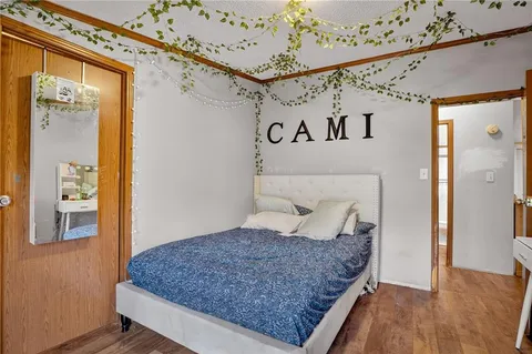 a bedroom with a large bed and a wooden floor