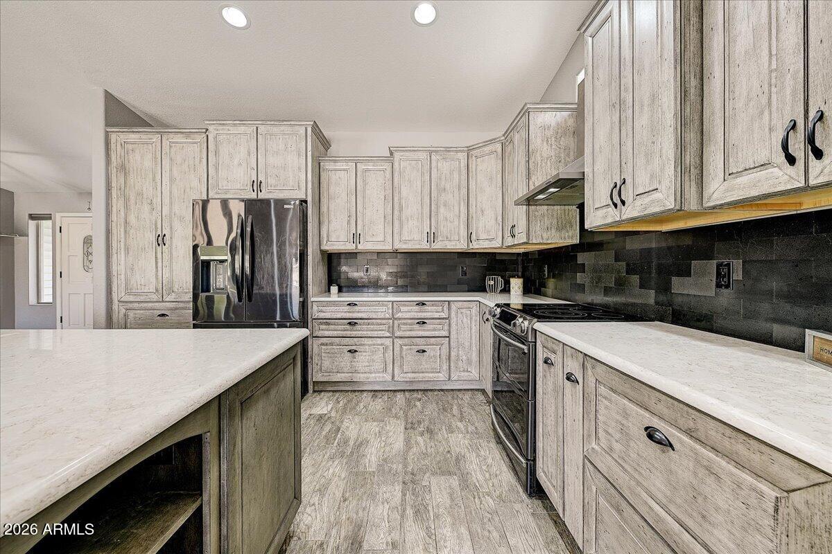 7624 North Citrus Road Waddell, AZ 85355 - Photo 17 of 57 a kitchen with white cabinets and stainless steel appliances