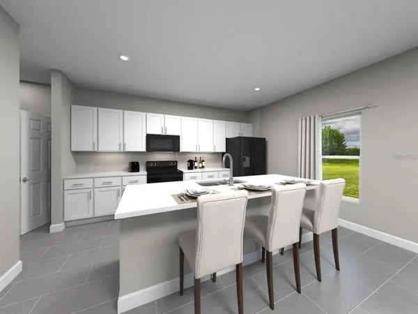 a kitchen with a dining table chairs and refrigerator
