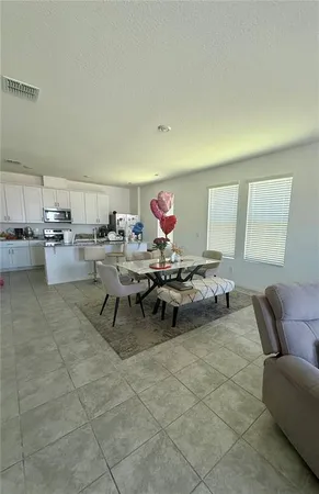 a living room with couches and kitchen view