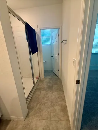 a bed sitting in a spacious bedroom next to a window and a larger closet