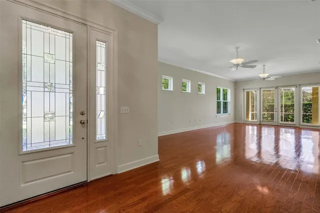 a view of an empty room with wooden floor and a window