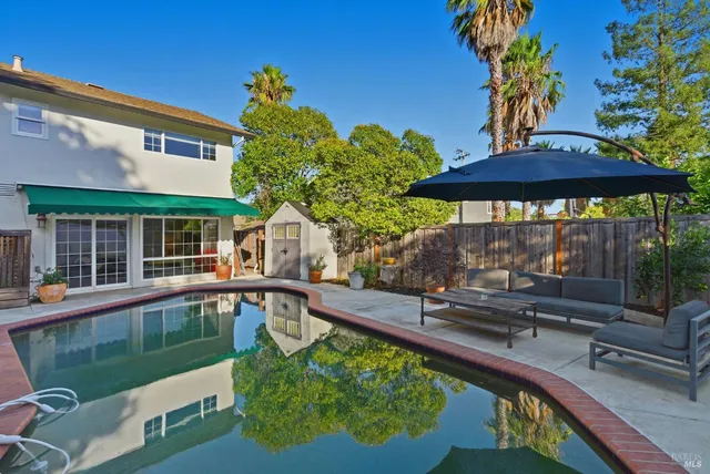a swimming pool view with a seating space
