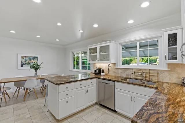 a kitchen with granite countertop stainless steel appliances white cabinets and a granite counter tops
