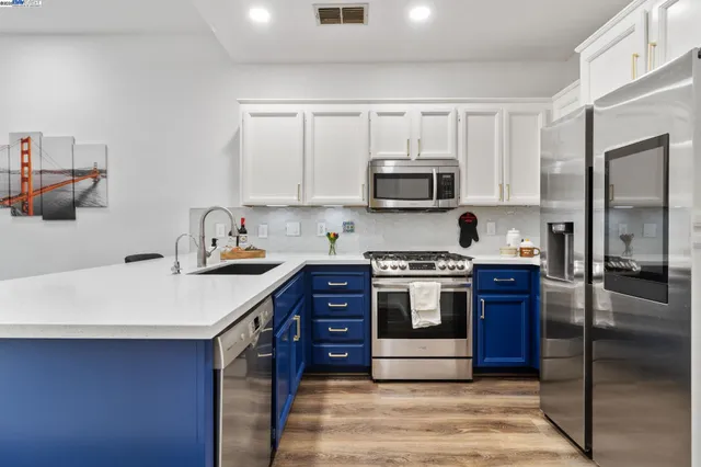 a kitchen with stainless steel appliances granite countertop a stove a sink and a refrigerator