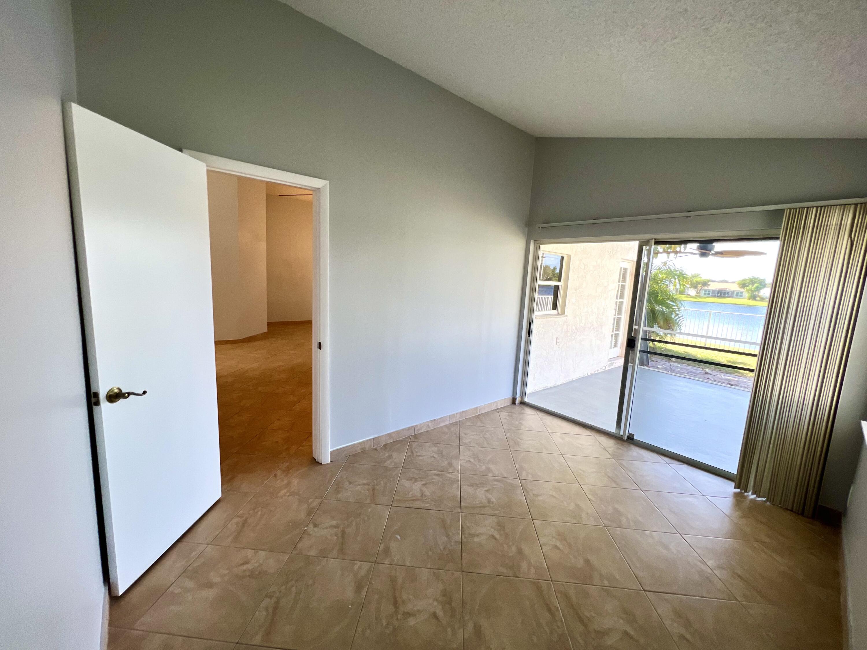 18859 La Costa Lane Boca Raton, FL 33496 - Photo 14 of 16 an empty room with large window and a hallway
