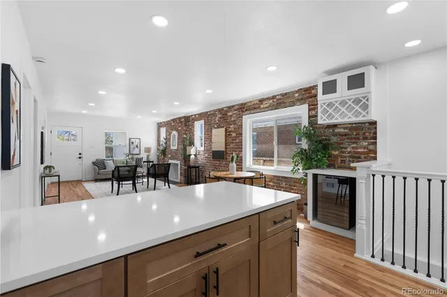 a kitchen with a sink stainless steel appliances and living room view