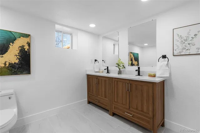 a bathroom with a sink a toilet and mirror