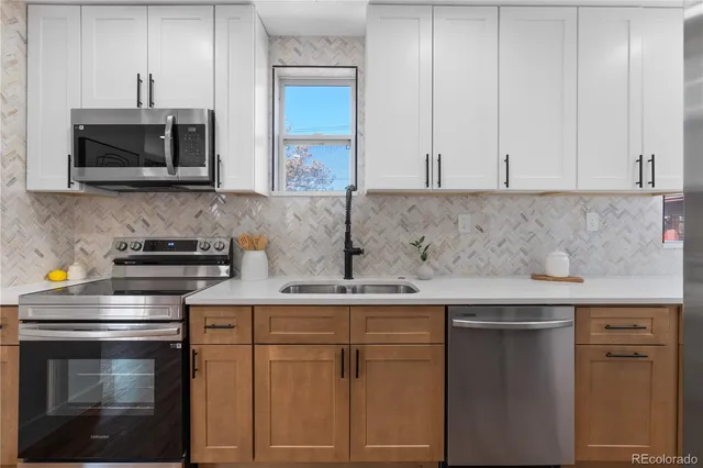a kitchen with stainless steel appliances granite countertop a sink stove and microwave