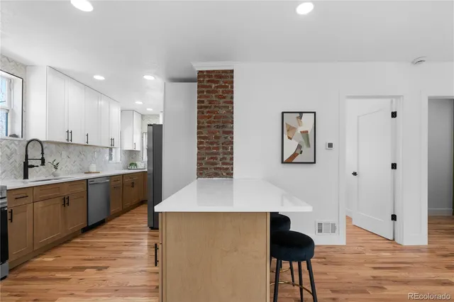 a large kitchen with stainless steel appliances lots of counter space and wooden floor