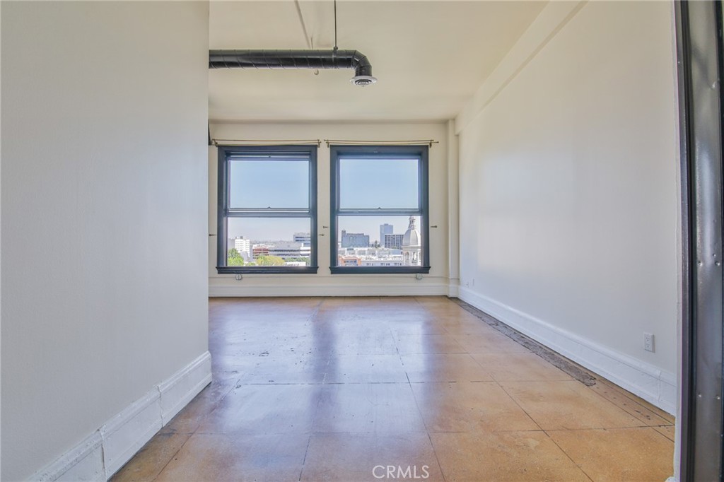 108 West 2nd Street, Unit 803 Los Angeles, CA 90012 - Photo 15 of 28 an empty room with wooden floor and windows