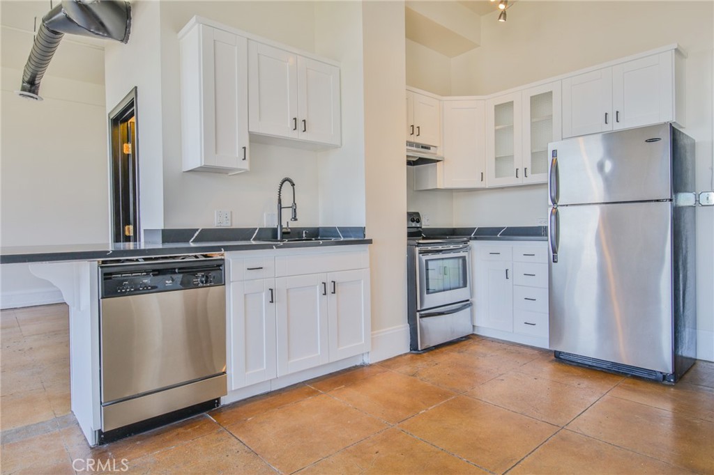 108 West 2nd Street, Unit 803 Los Angeles, CA 90012 - Photo 9 of 28 a kitchen with stainless steel appliances a stove a sink and a refrigerator