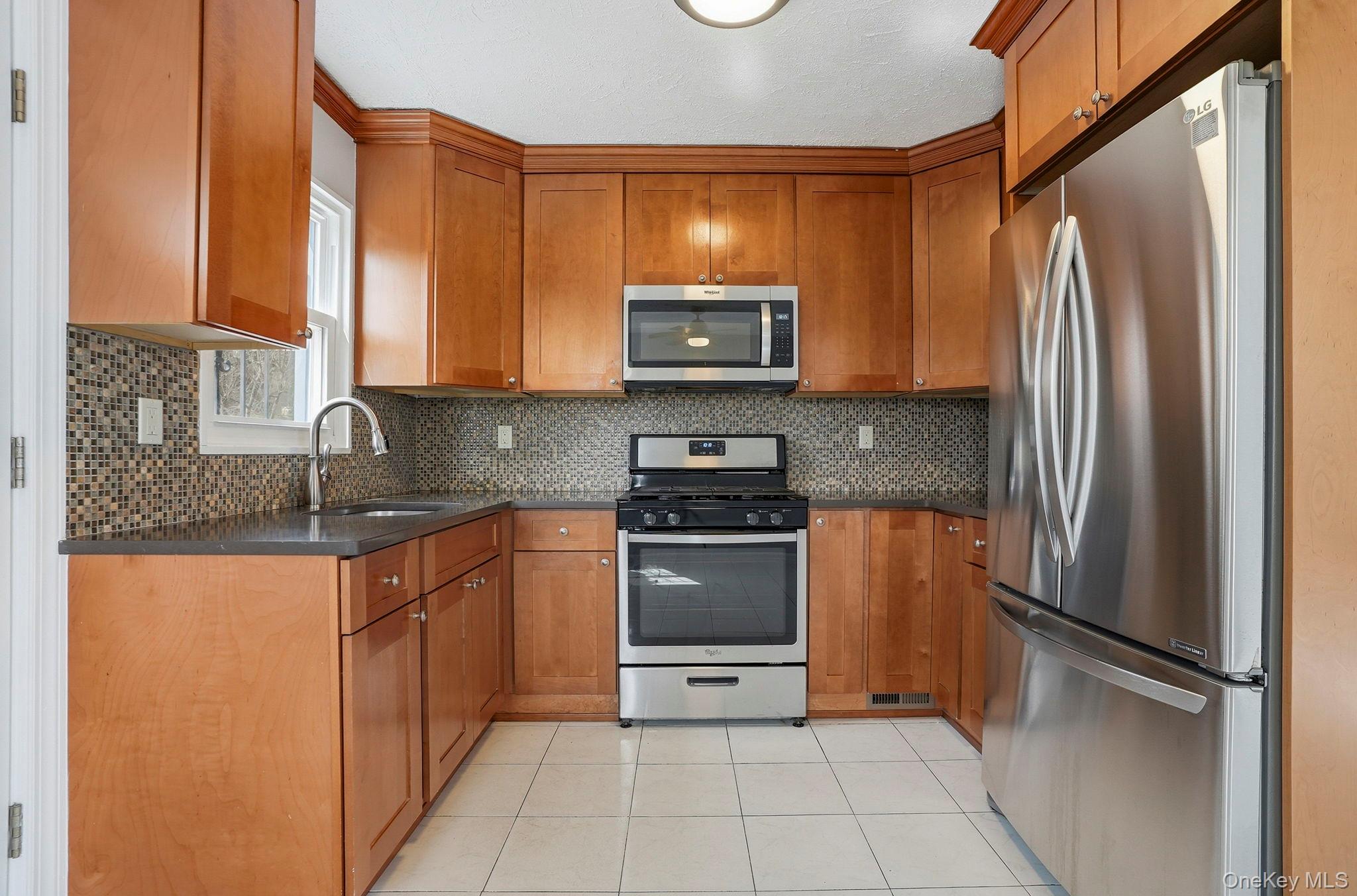 71 Glen Road Yonkers, NY 10704 - Photo 9 of 30 a kitchen with stainless steel appliances granite countertop a refrigerator and a sink