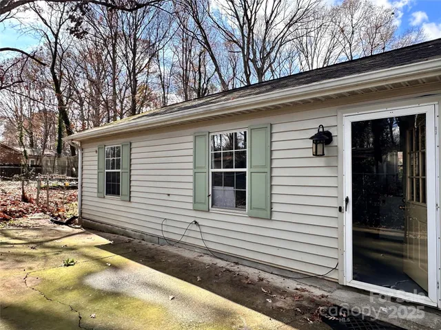 a view of a house with a yard and large tree