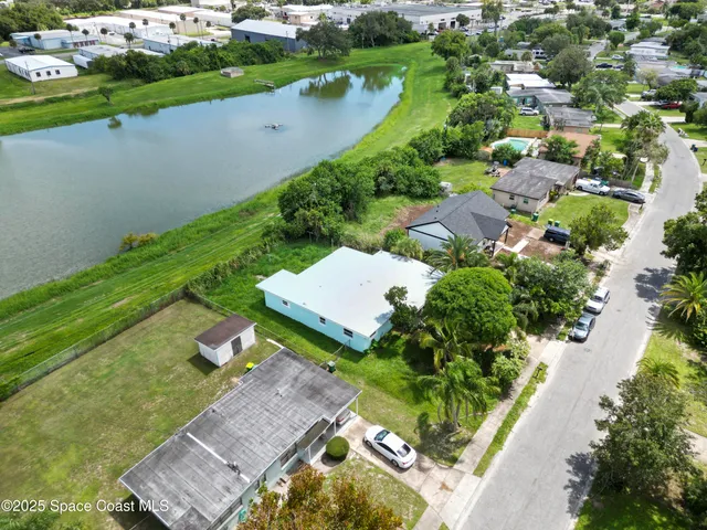an aerial view of a house with a garden and lake view