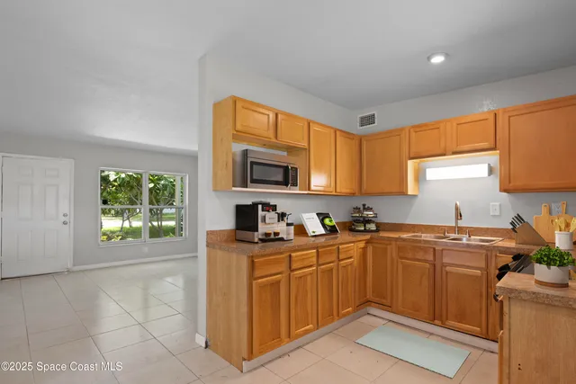 a kitchen with a sink a window and cabinets