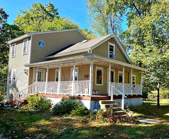 a front view of a house with a yard and a garden