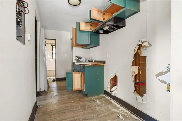 a view of an empty room with wooden floor and closet