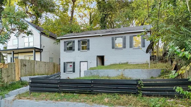 a front view of a house with garden and trees