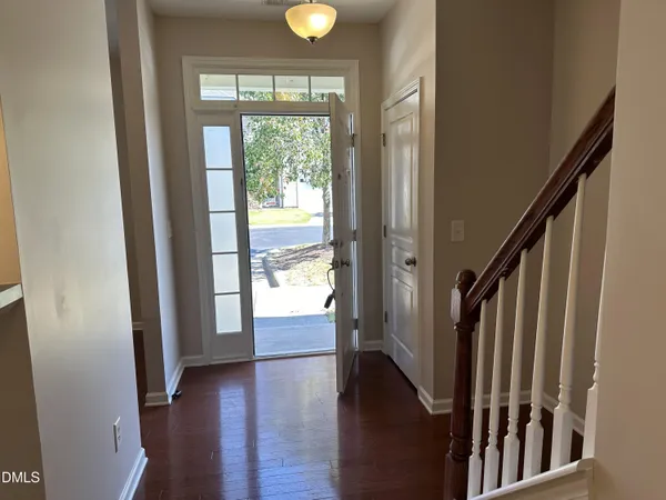 a view of an entryway with wooden floor and door