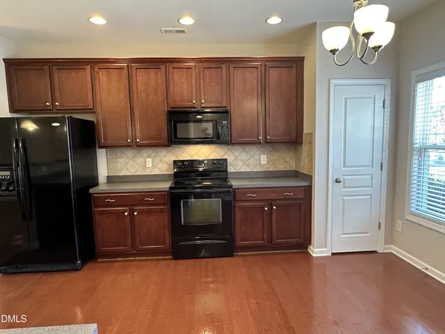 a kitchen with stainless steel appliances granite countertop a stove a refrigerator and a microwave