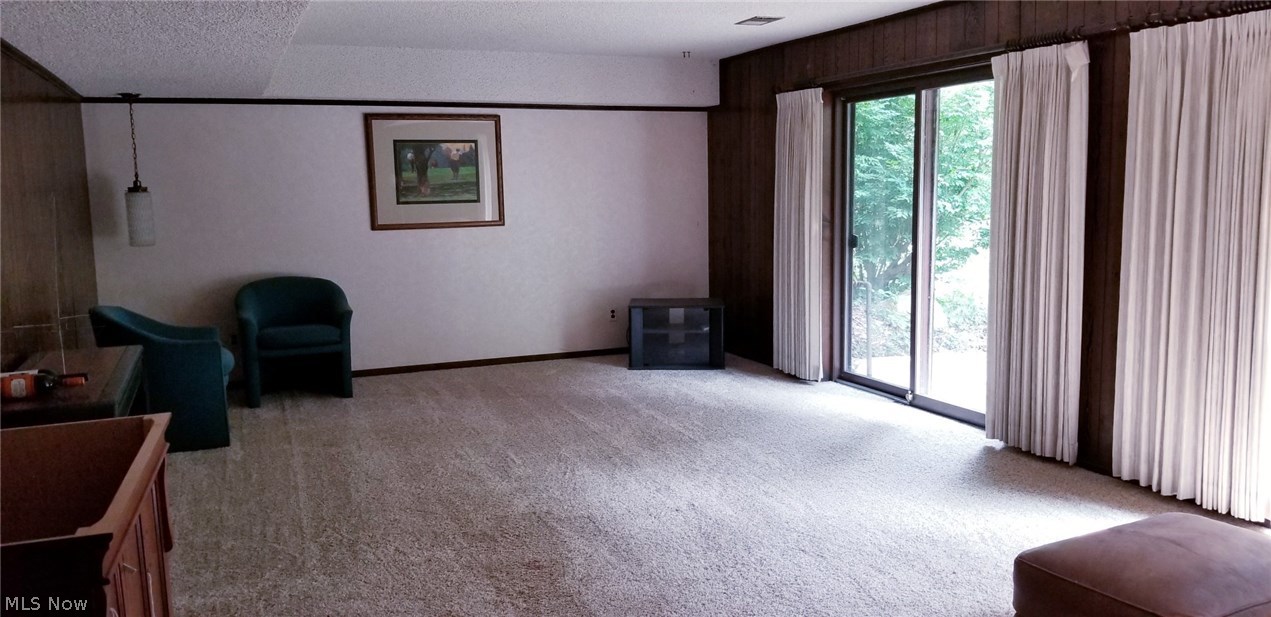 1261 Sand Run Road Akron, OH 44313 - Photo 25 of 32 The finished walk-out lower level. Newer carpet in this room. Sliders to the outside patio and beyond. A full bath is being completely renovated just off of the area.