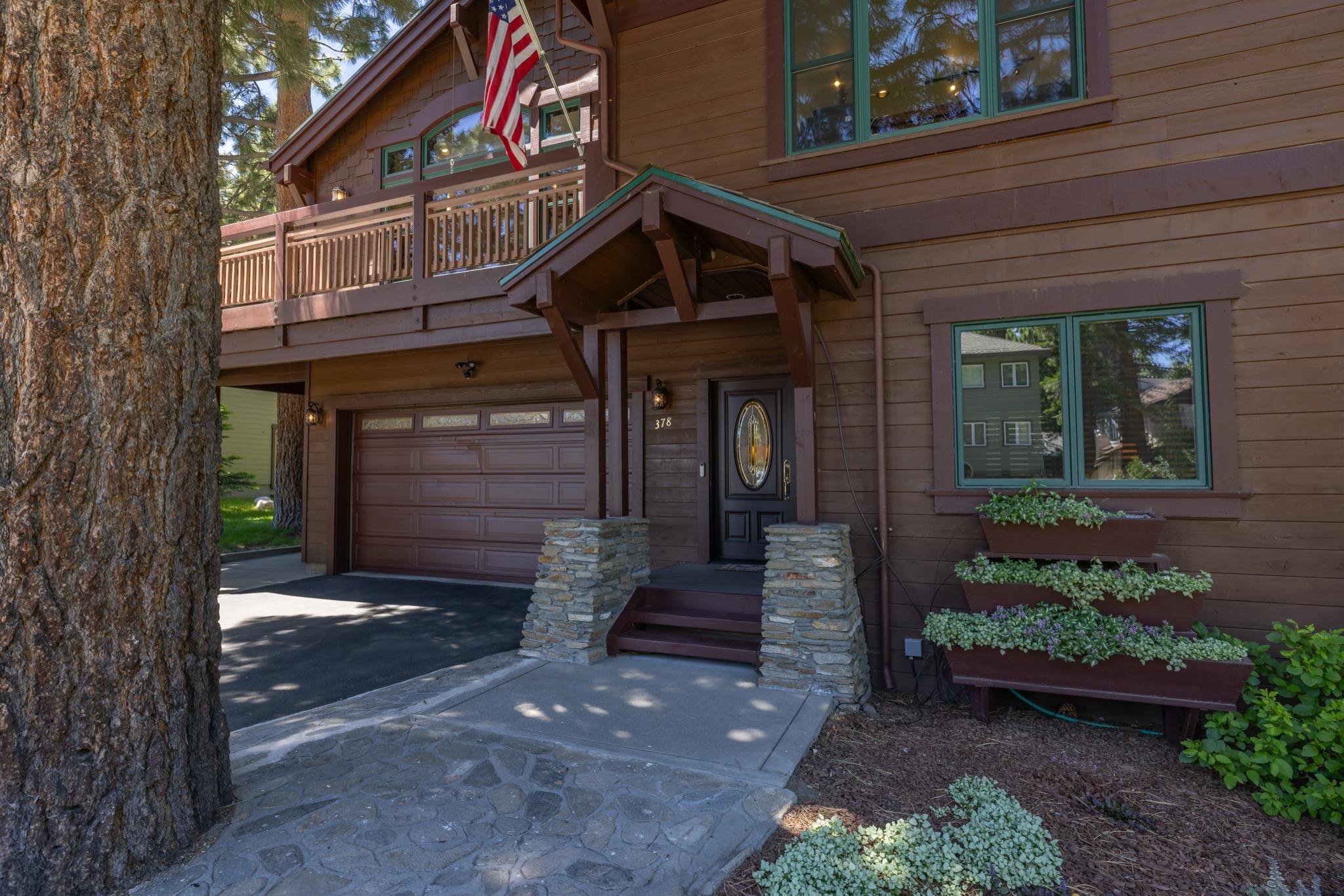 378 Ridge Way Mammoth Lakes, CA 93546 - Photo 2 of 43 Wood-sided exterior with green-trimmed windows, a stone-clad entry, and a covered front porch