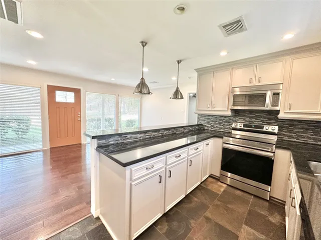 a kitchen with stainless steel appliances granite countertop a stove and a sink