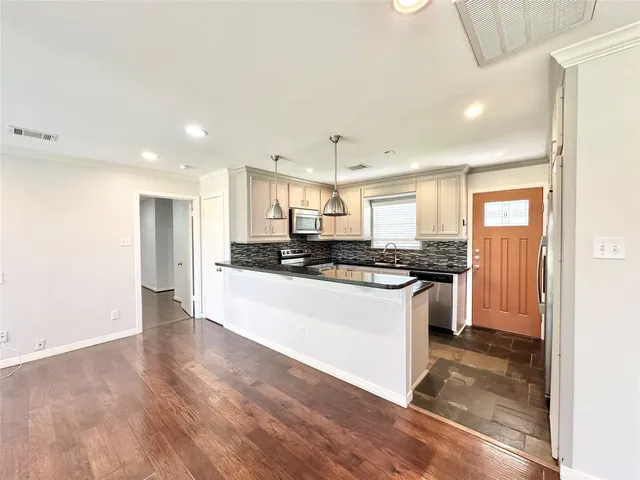 a kitchen with stainless steel appliances granite countertop a stove a sink and a refrigerator