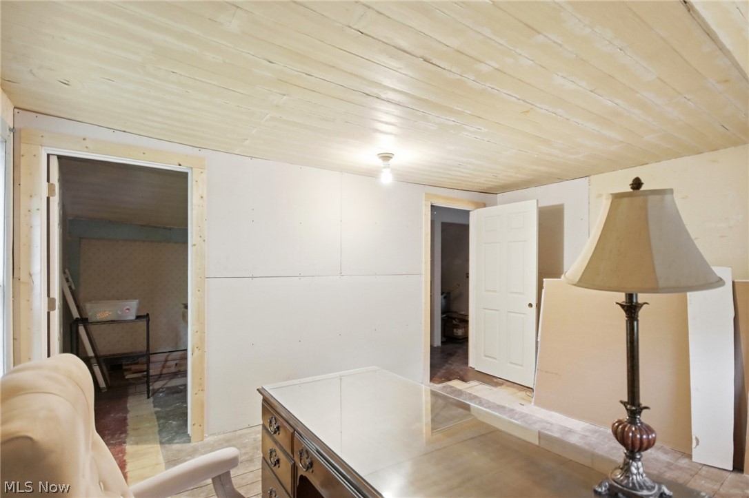 2591 Wayland Road Deerfield, OH 44411 - Photo 28 of 46 Room featuring a light-colored wood-plank ceiling, exposed drywall, and a doorway with unfinished wood trim
