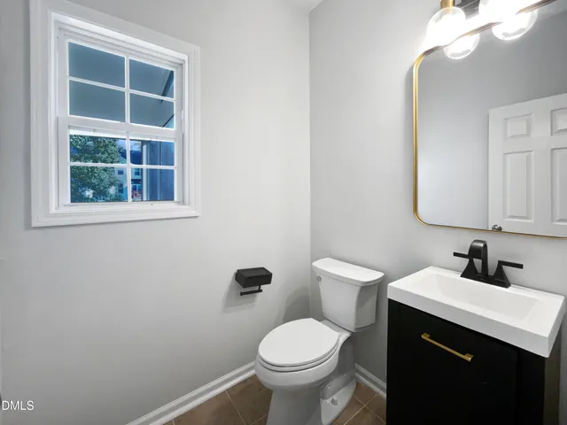 a bathroom with a toilet sink vanity and mirror