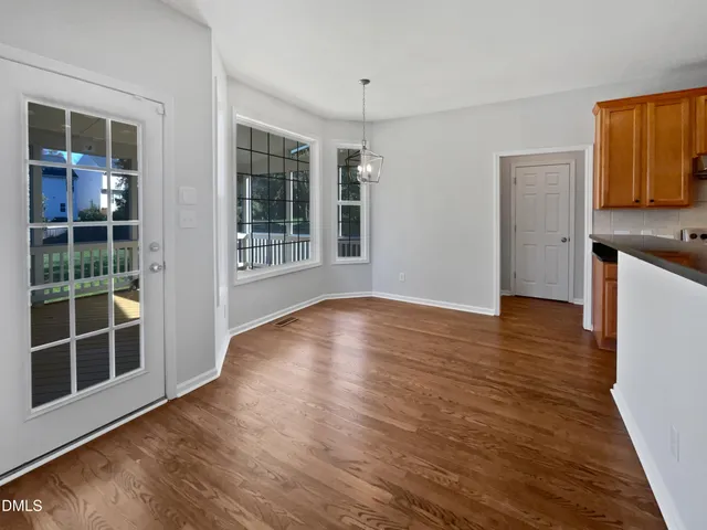 a view of a kitchen with wooden floor and a window