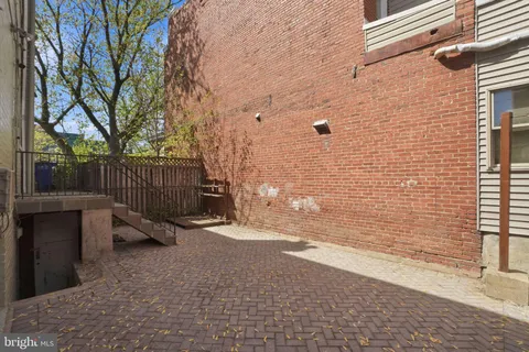 a bedroom with a bed a couch and a potted plant