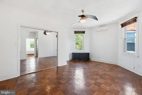 an empty room with closet and a chandelier fan