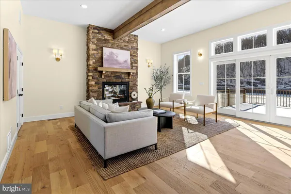 a dining room with wooden floor and large windows