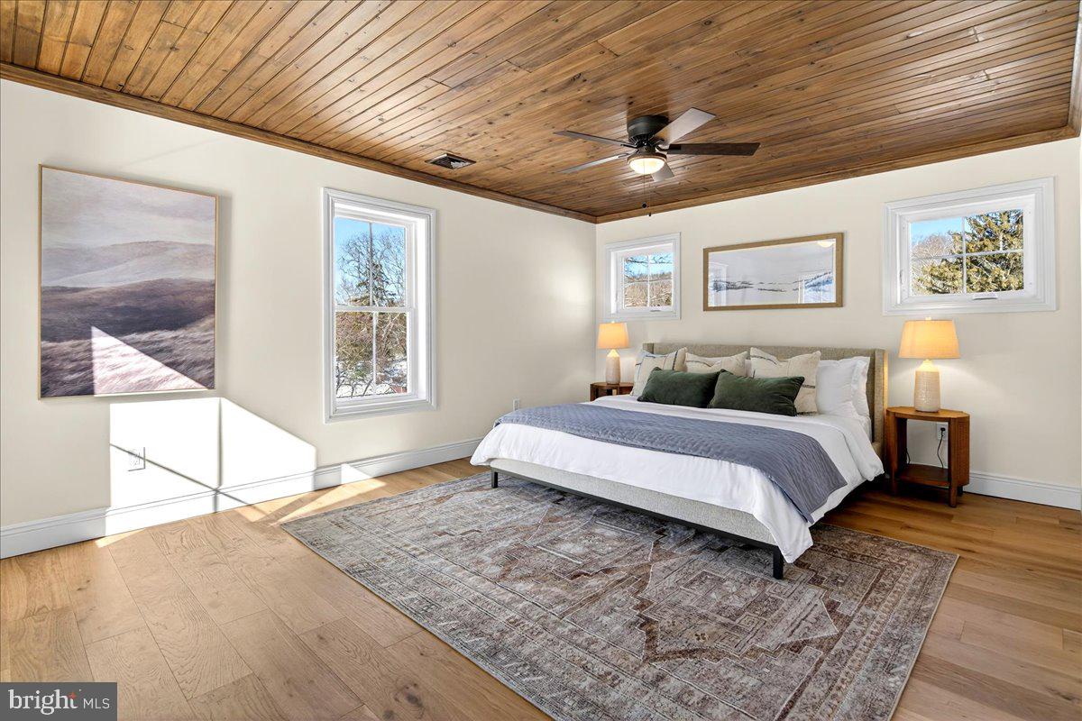 159 Byram Lane Stockton, NJ 08559 - Photo 37 of 62 a spacious bedroom with a large bed and a chandelier