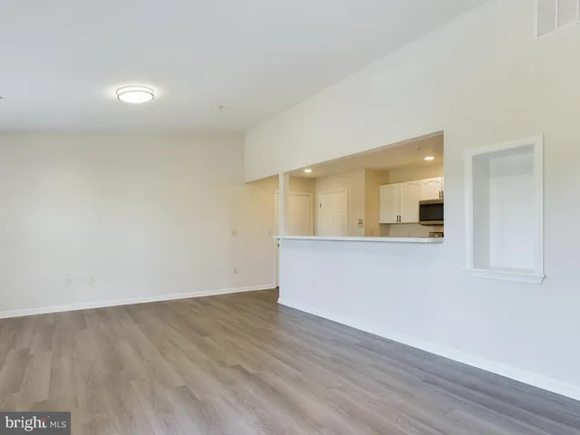 an empty room with wooden floor and mirror