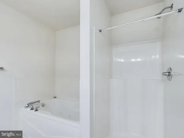 a white bath tub sitting next to a shower