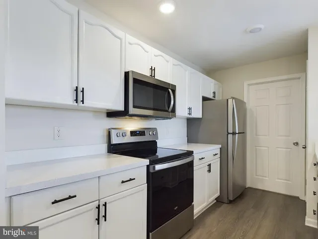 a kitchen with stainless steel appliances a stove microwave and refrigerator