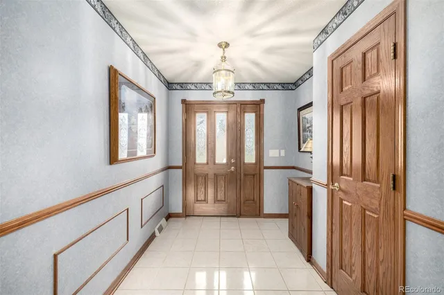 a view of entryway with chandelier and front door
