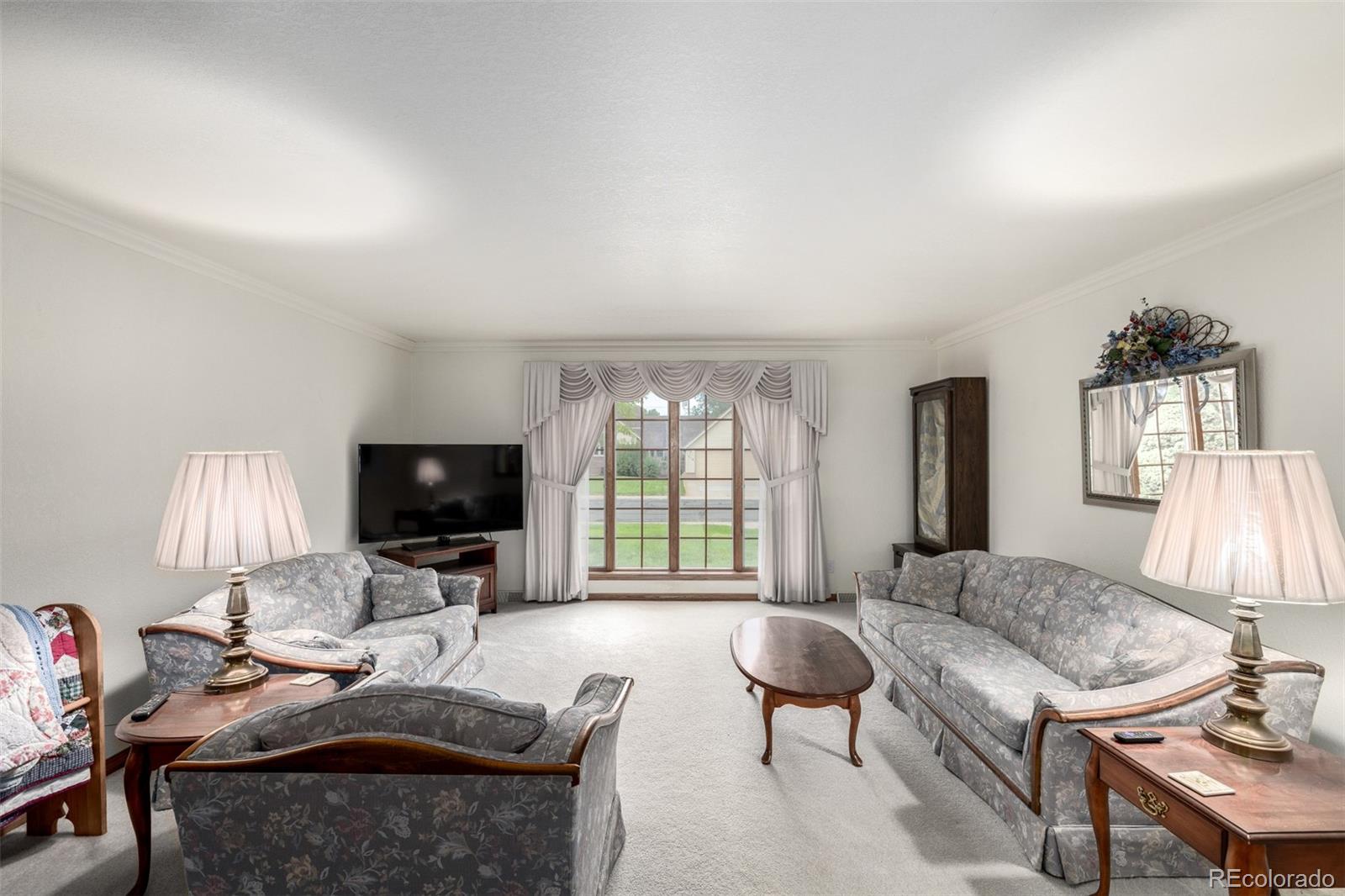 909 Fairhurst Street Sterling, CO 80751 - Photo 12 of 50 a living room with furniture and a flat screen tv