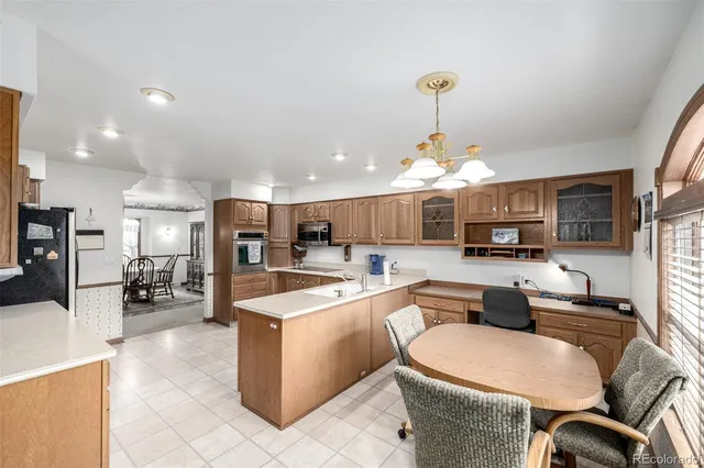 a kitchen with stainless steel appliances granite countertop a sink dishwasher a stove a refrigerator a kitchen island with chairs and cabinets